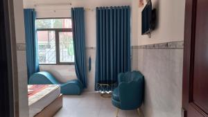 胡志明市Khách Sạn Nguyên Trung的一间设有蓝色椅子和窗户的客房