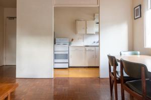 悉尼Light-Filled Paddington Studio with Parking的厨房配有白色家电和桌椅