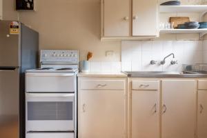悉尼Light-Filled Paddington Studio with Parking的厨房配有白色橱柜和冰箱。
