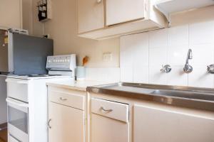 悉尼Light-Filled Paddington Studio with Parking的一间带水槽和冰箱的小厨房
