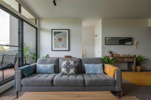 悉尼Treetops Camperdown Inner City Bliss w Parking的客厅配有带枕头的灰色沙发