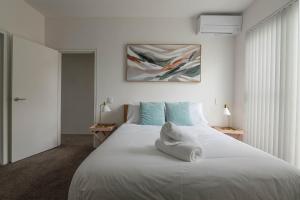悉尼Treetops Camperdown Inner City Bliss w Parking的卧室配有带蓝色枕头的大型白色床