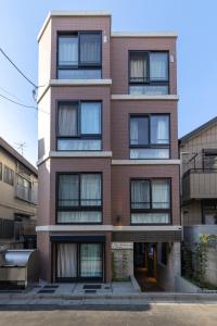 东京67Hotel Koenji Tokyo的一座高大的砖砌建筑,有很多窗户