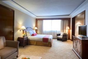 宿务Marco Polo Plaza Cebu的酒店客房,配有床和电视