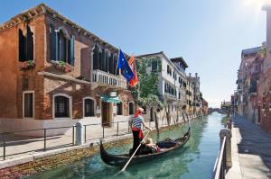 威尼斯梅斯纳尔酒店的一个人在运河上划上一条船
