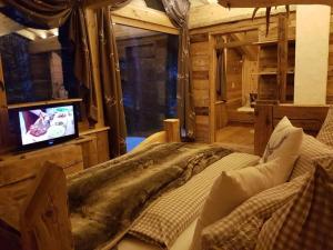 格伦Lush holiday home with sauna的小屋内设有一间带床铺和电视的卧室