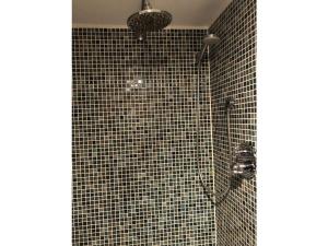Holiday apartment oasis的浴室设有黑色瓷砖淋浴。