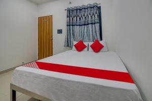 那格浦尔OYO Flagship Hotel Roman Inn的一间卧室配有一张带红色枕头的大床