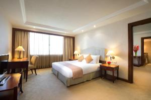 宿务Marco Polo Plaza Cebu的酒店客房配有一张床、一张书桌和一台电脑