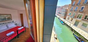 威尼斯梅斯纳尔酒店的卧室设有河景窗户。