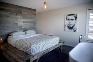 AlonnahCouples Getaway on Bruny Island的一间卧室设有一张床和木墙