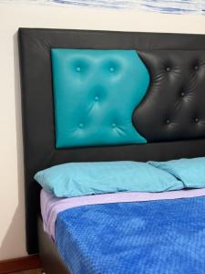 波哥大Hostel Bogotá Niza Tu sitio的床头板,床上有蓝色的枕头