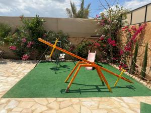 Al Ramaشاليه البحر الميت الرامة-Deadsea的两把椅子和绿地毯上的秋千