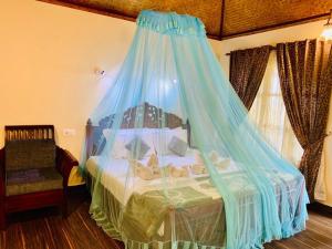 瓦尔卡拉Maadathil Beach Resort的一间卧室配有一张带蓝色蚊帐的床