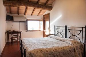 卡斯蒂戈隆·多尔希亚波吉欧阿尔温托旅馆的一间卧室配有一张床、一张书桌和一个窗户。