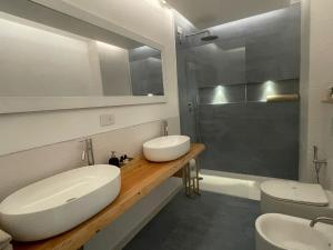 CarlinoAgriturismo Valle Ca' del Lovo的一间带两个盥洗盆和淋浴的浴室
