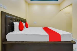 ItwāriOYO Flagship Heritage Farm Resort的一间卧室配有红色枕头的床
