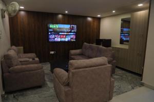 蒂鲁帕蒂Nakshatra grand的客厅配有2把椅子和平面电视