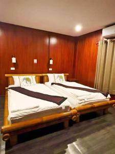 万荣Vang Vieng Garden Villa的木墙客房的两张床