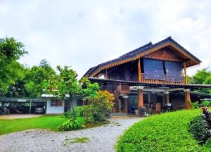 万荣Vang Vieng Garden Villa的一座带绿色庭院的大型木屋