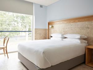 Mount PritchardGreen Valley Hotel的卧室设有一张白色大床和一扇窗户。