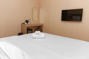 阿克套Aston Hotel的一间卧室配有一张床,上面有两条毛巾