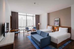 雅加达Veranda Serviced Residence Puri的配有一张床和一张书桌的酒店客房
