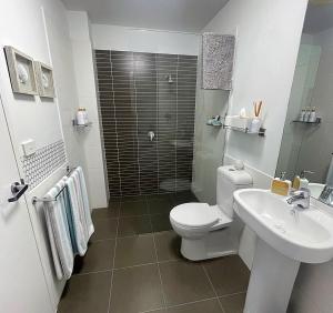纽卡斯尔AQUA 306 POOLSIDE Luxury Apartment , Honeysuckle, NEWCASTLE FREE Parking的浴室配有卫生间、盥洗盆和淋浴。
