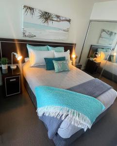 纽卡斯尔AQUA 306 POOLSIDE Luxury Apartment , Honeysuckle, NEWCASTLE FREE Parking的一间卧室配有一张带蓝白色枕头的大床