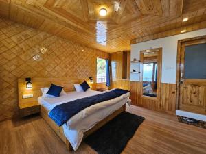 CheogZen Homestay的木制客房内的一间卧室配有一张大床