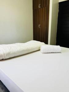 金贾Malaika Homes Jinja的卧室配有2张白色床和衣柜