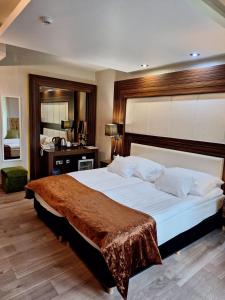 布达佩斯多瑙花园酒店的一间卧室配有一张大床,床上铺有棕色毯子