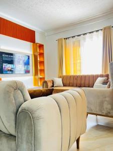 金贾Malaika Homes Jinja的客厅配有两张沙发和一张沙发