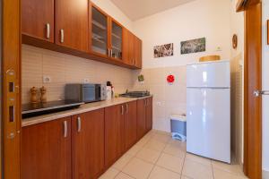 布德瓦Family One bedroom apartment with Panoramic city view的厨房配有木制橱柜和白色冰箱。