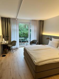 巴德茨维什安米尔汉森之家酒店的一间卧室配有一张床、一张书桌和一个窗户。