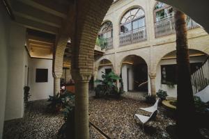 科尔多瓦沁园珀萨德罗精品酒店的建筑中带椅子和植物的室内庭院