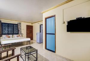 卡兰古特Super OYO Pravin Holiday Homes的客厅设有床铺和墙上的电视