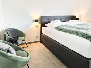 锡根SI-View Doppelzimmer mit Stadtblick Zimmer 21的一间卧室配有一张大床和两把椅子