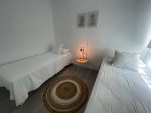 宏达海滩White Serenity的客房设有两张床和一张带台灯的桌子。