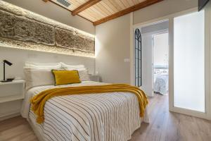马林Apartamento Almuiña的一间卧室配有一张黄色枕头的床