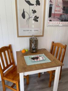 隆德Tiny house Lund的餐桌,配有两把椅子和一张带花瓶的桌子