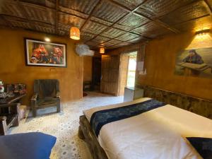 河江Ha Giang Xanh Retreat, Tour and Motorbike Rental的一间卧室配有一张床和一把椅子