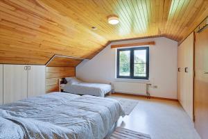 胡塔伦Holiday home in the greenery of Limburg的一间卧室设有两张床和木制天花板