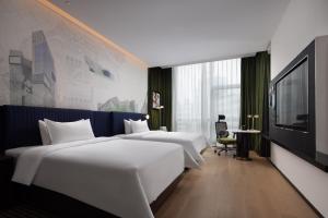 深圳深圳南山科技园希尔顿欢朋酒店的一间酒店客房,设有两张床和电视