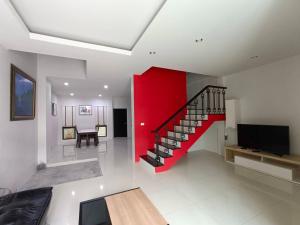 Ban Phlu YaiSino Village的客厅设有楼梯和红色的墙壁