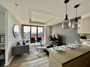 危地马拉Hemen - Luxury Apartment with pool的厨房以及带沙发和桌子的客厅。