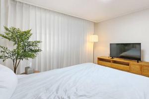 首尔#guro digital complex station 10min #clean #2rooms #netflix的一间卧室配有一张床和一台平面电视