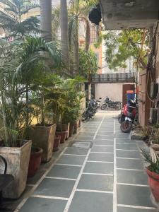 新德里Hotel Saket Place - Near Saket Metro的一座楼里种有棕榈树和摩托车的庭院