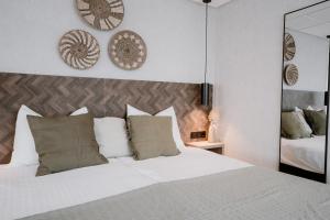 阿赫特克克Kodde Studio的卧室配有带枕头和镜子的白色床