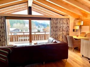 奥伯斯特多夫Alpenlodge Charivari - SommerBergBahn unlimited kostenlos的带沙发和大窗户的客厅